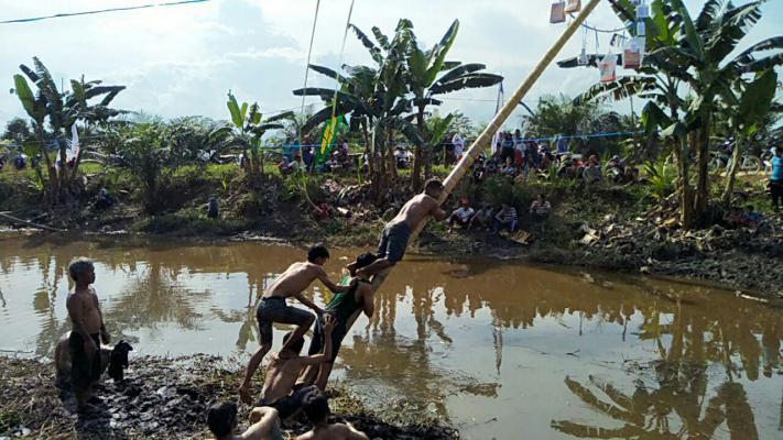 Panjat Pinang Versi di Kali Tajaan Koramil Rengat Disambut Antusias warga