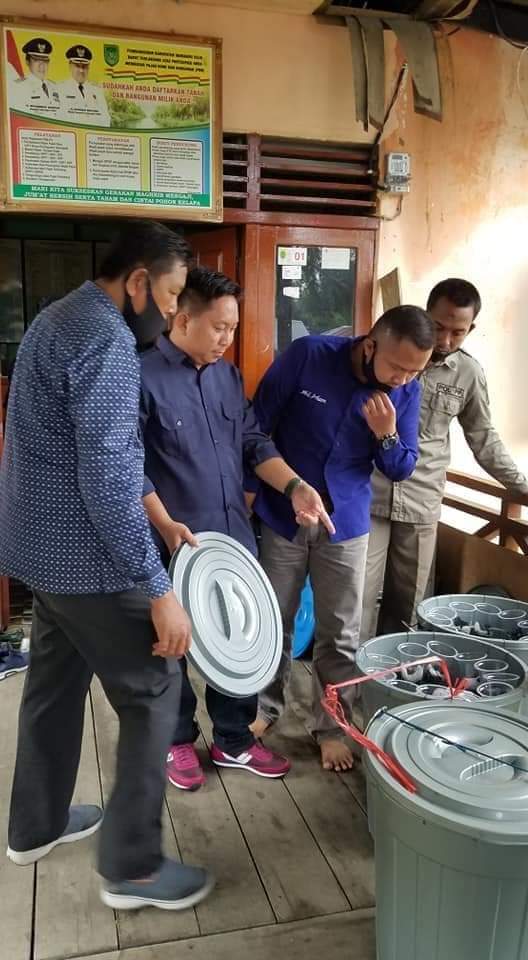 M. Taufik didampingi Sekretaris Nasdem Inhil, Muhammad Irham mengenalkan cara budi daya ikan dalam ember.