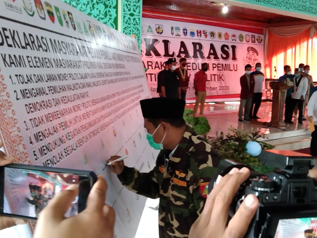 Ketua PW Ansor Riau, Purwaji menandatangani deklarasi anti politik uang.